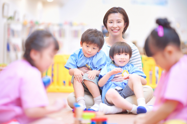 子供たちを見る女性スタッフ